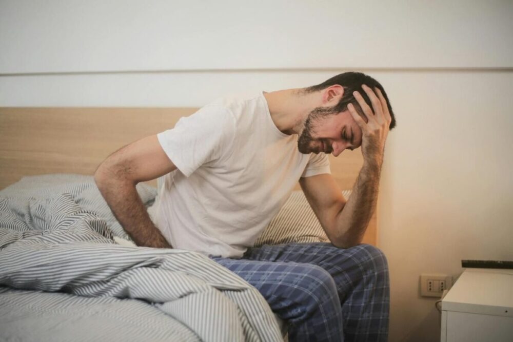 A man in sleepwear experiencing pain.