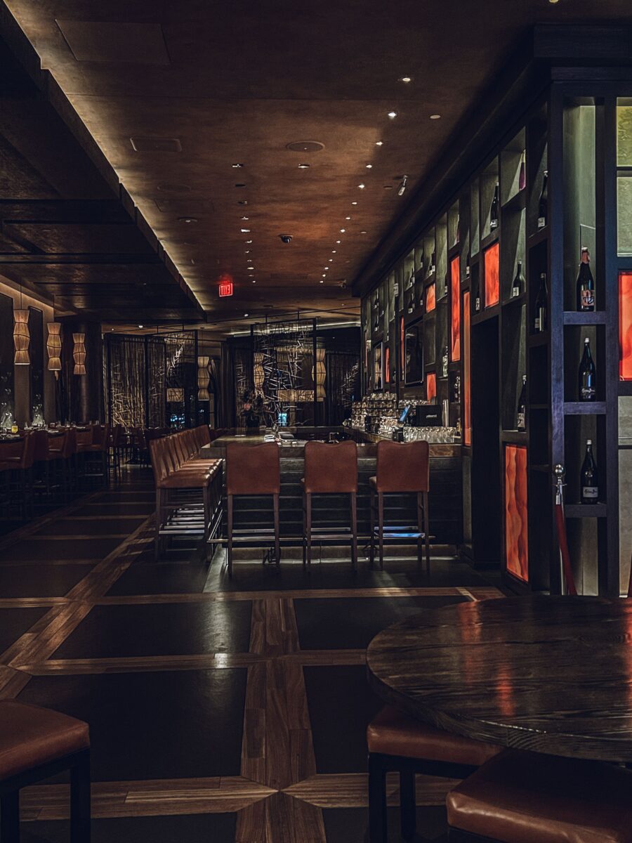 Modern lounge with stylish seating and warm ambient lighting, evoking discreet upscale nightlife