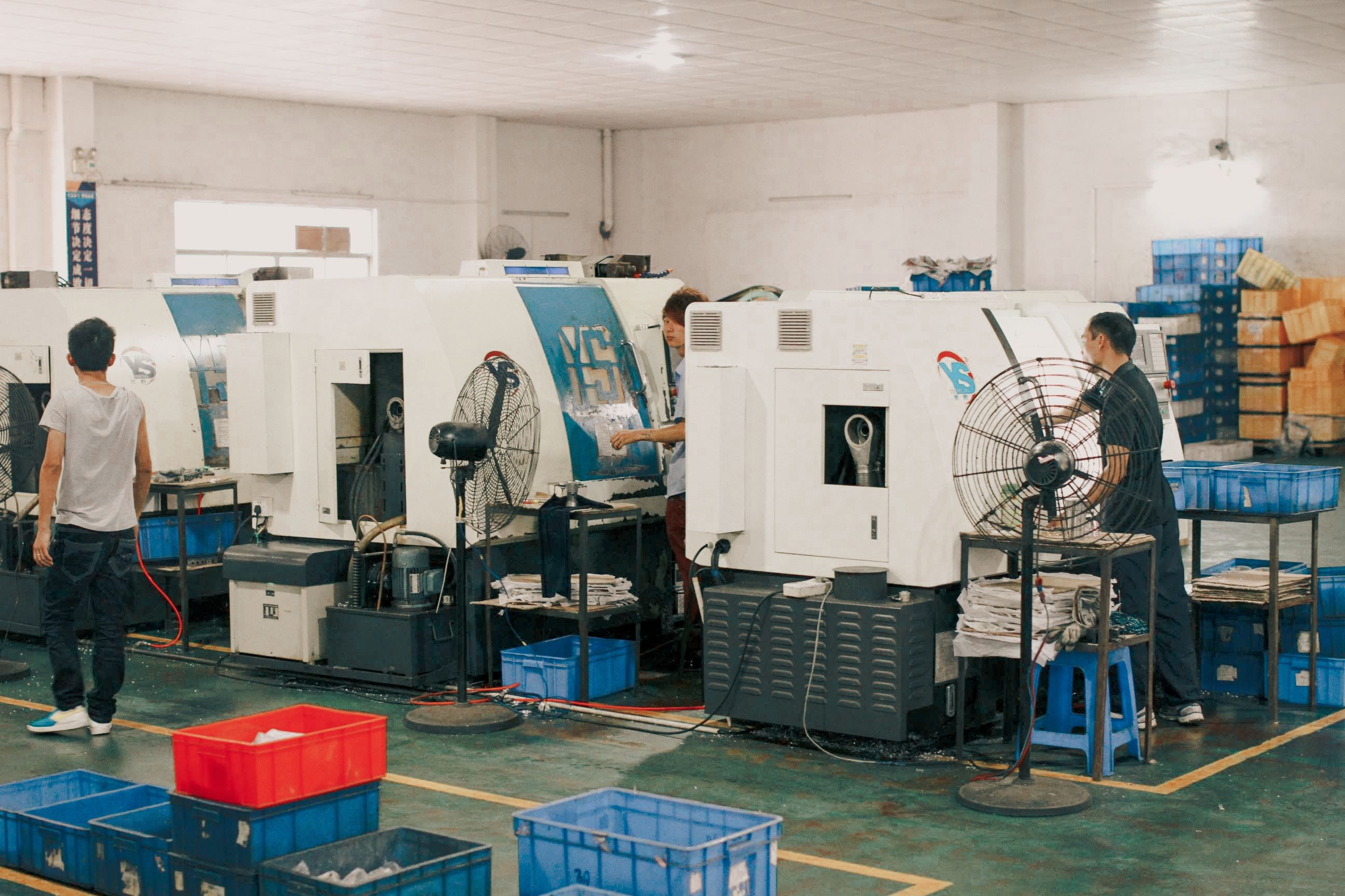 Workers operating machinery on a vape hardware manufacturing factory line