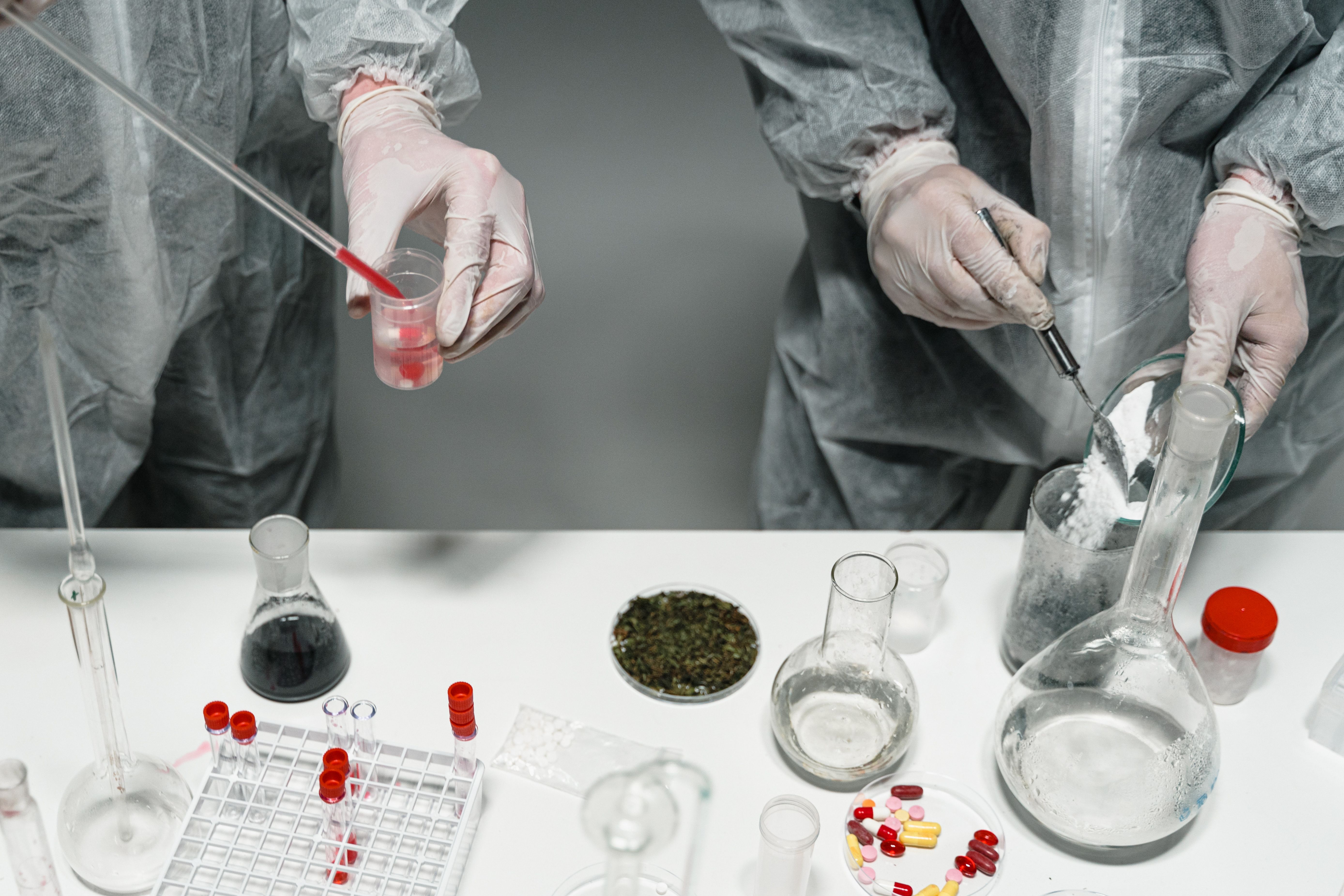 Scientists in protective gear running quality control tests in a laboratory